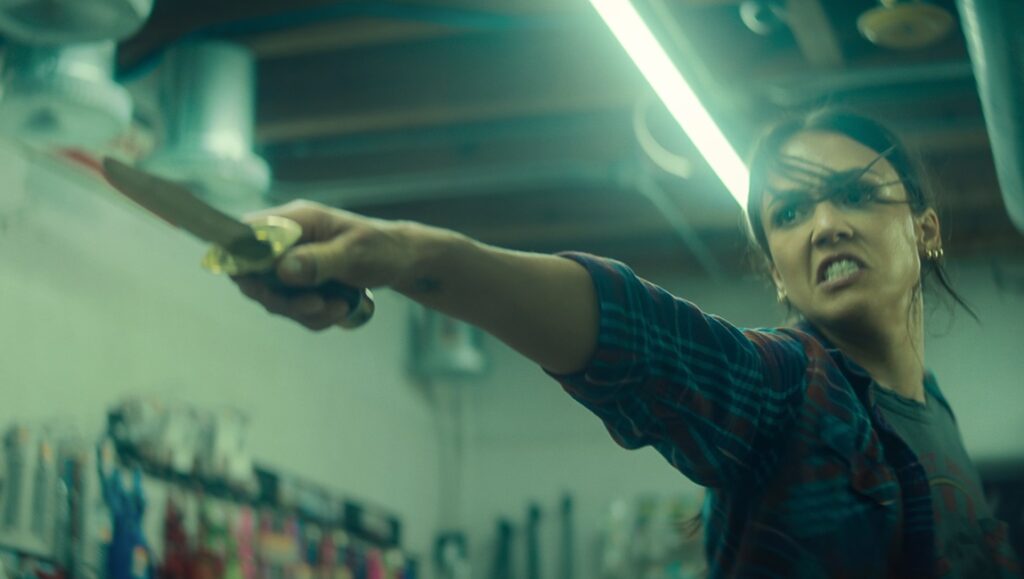 Trigger Warning movie scene: Jessica Alba wields a knife, intense expression. Action film, thriller.