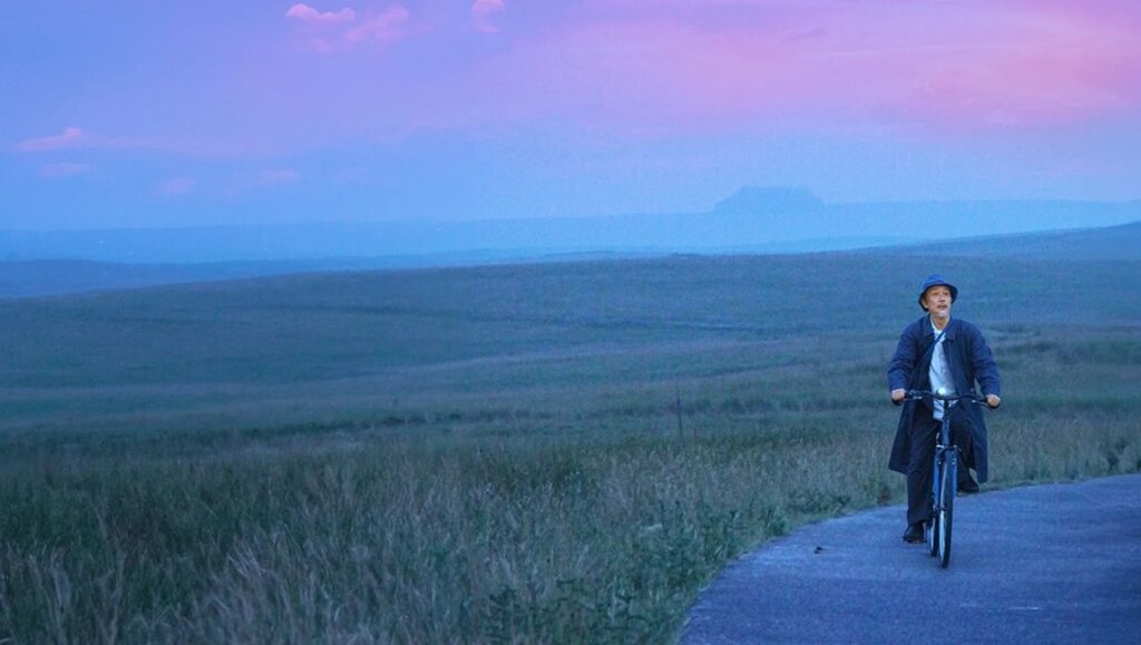 Cottontail review: Patrick Dickinson cycles through a field at dusk. Indie film scene.