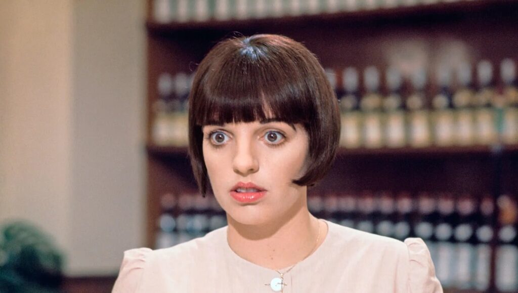 Liza Minnelli in A Matter of Time film. Actress with bob haircut, surprised expression. Classic Minnelli movie.