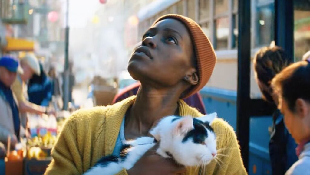 A Quiet Place: Day One movie image. Woman with cat looks up in fear.