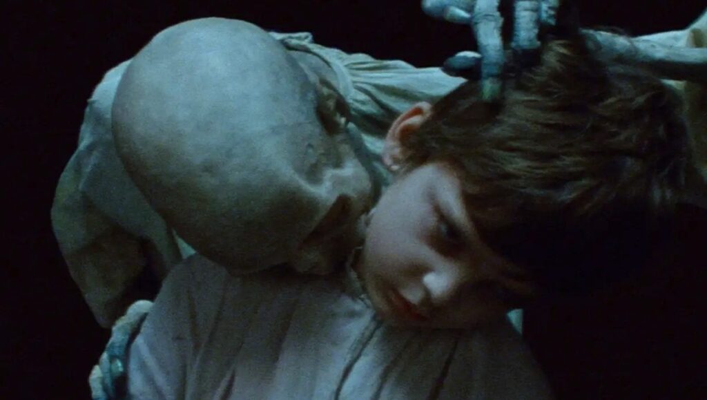 The Vourdalak movie still: Child with a pale, undead figure. Horror film scene.