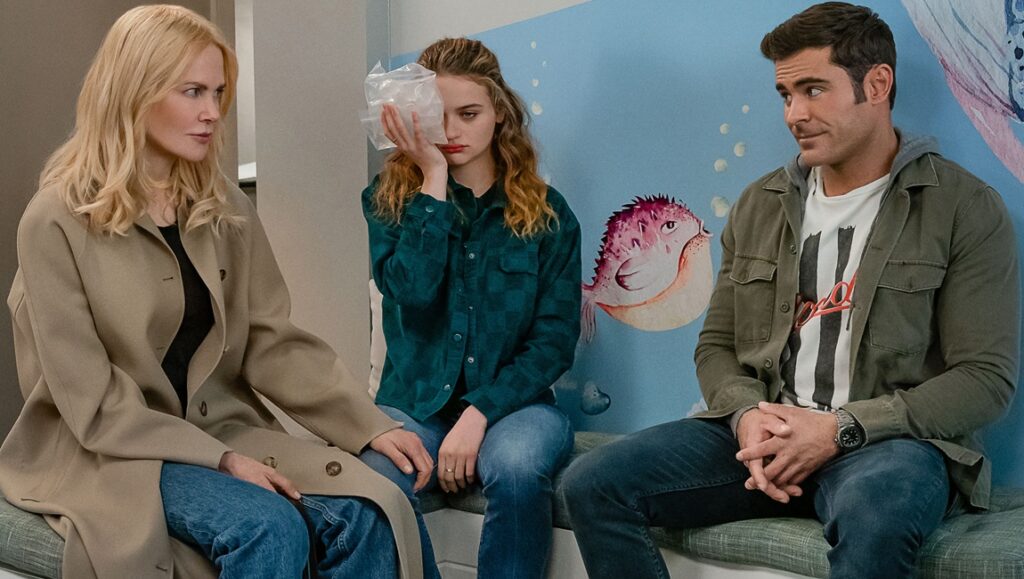 A Family Affair movie scene: Nicole Kidman, Joey King with ice pack, and Zac Efron sit together.