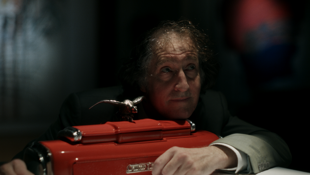 Chris Skotchdopole's Crumb Catcher review. Man with red crumb sweeper and eagle ornament.