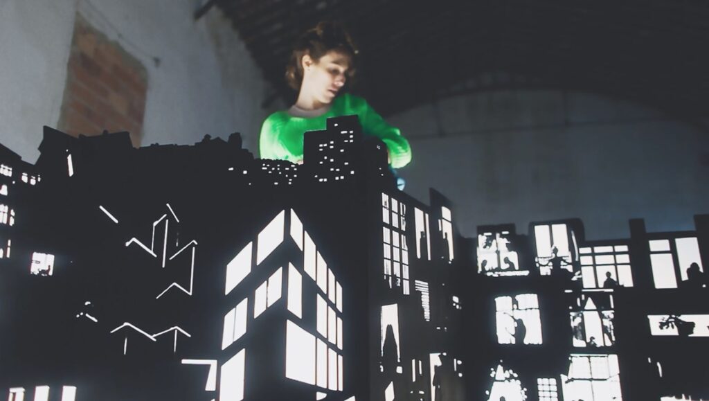 Jessica Dunn Rovinelli's Life Story film review. Dark silhouette of city buildings with lit windows. FIDMarseille '24.