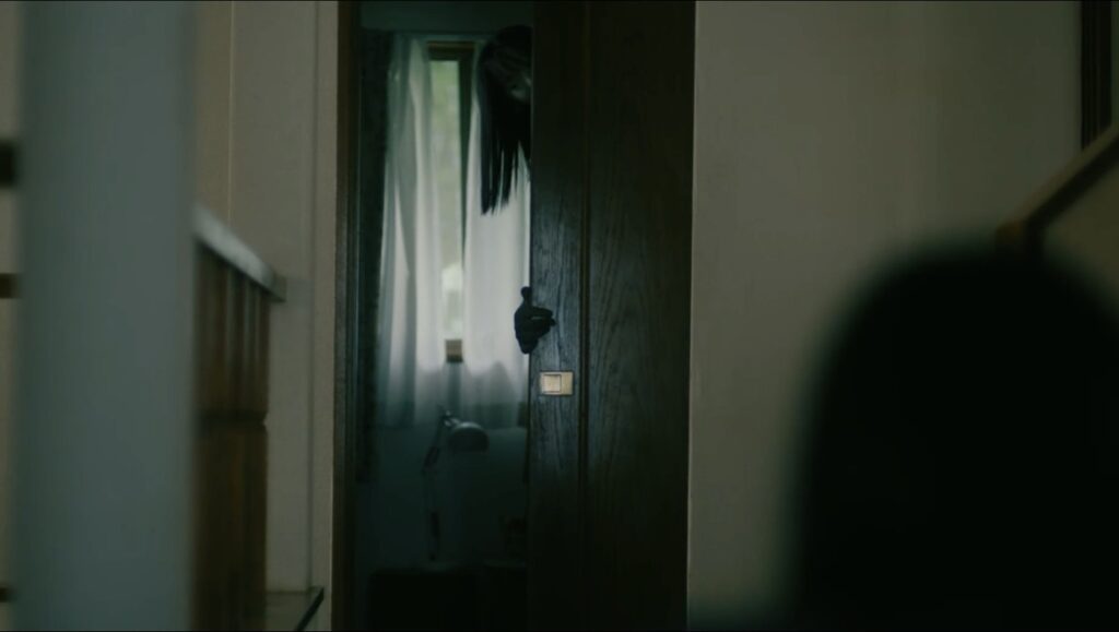 House of Sayuri film still. Ghostly figure peers from a doorway in a horror scene. Fantasia Fest 2024.