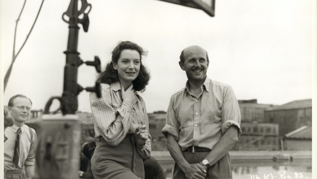 Powell and Pressburger film still. A man and woman smile in this black and white image from Made in England.