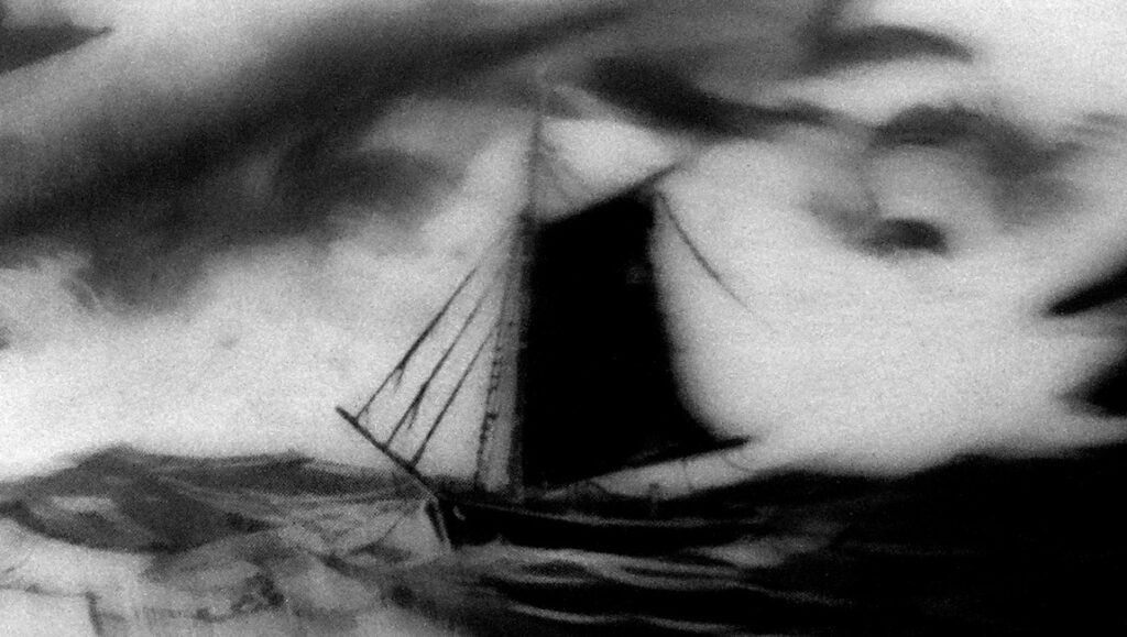 Black and white image of a sailboat navigating stormy seas. FIDMarseille '24 review.