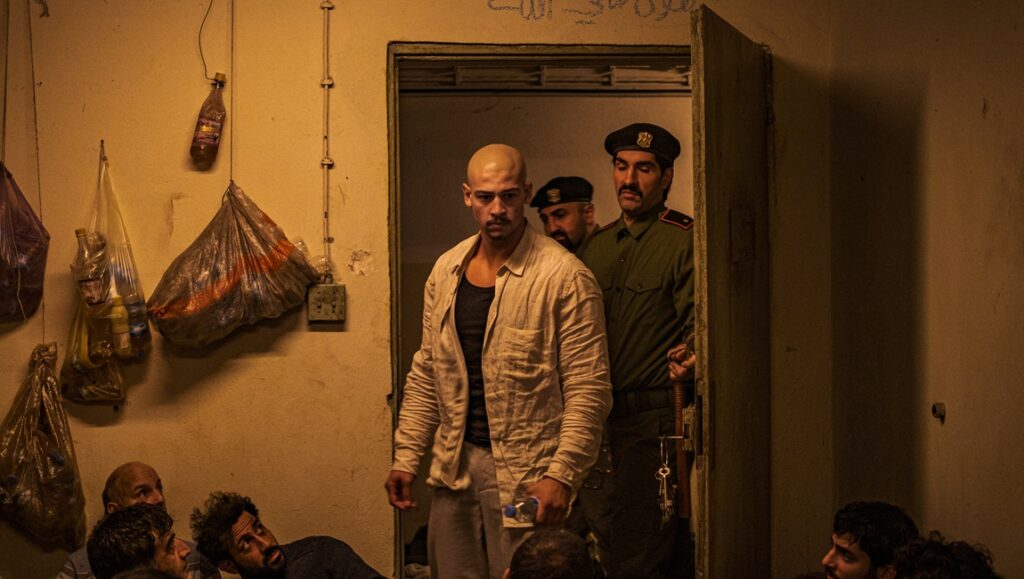 Rhinegold movie scene: Emilio Sakraya as Xatar, escorted by guards in a prison cell. Fatih Akin film review.