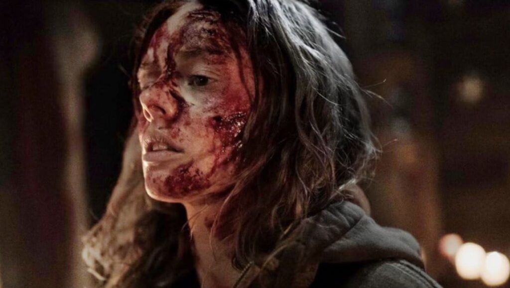 Woman with blood on her face. Horror movie scene. Dark hair, serious expression. Scary, intense.