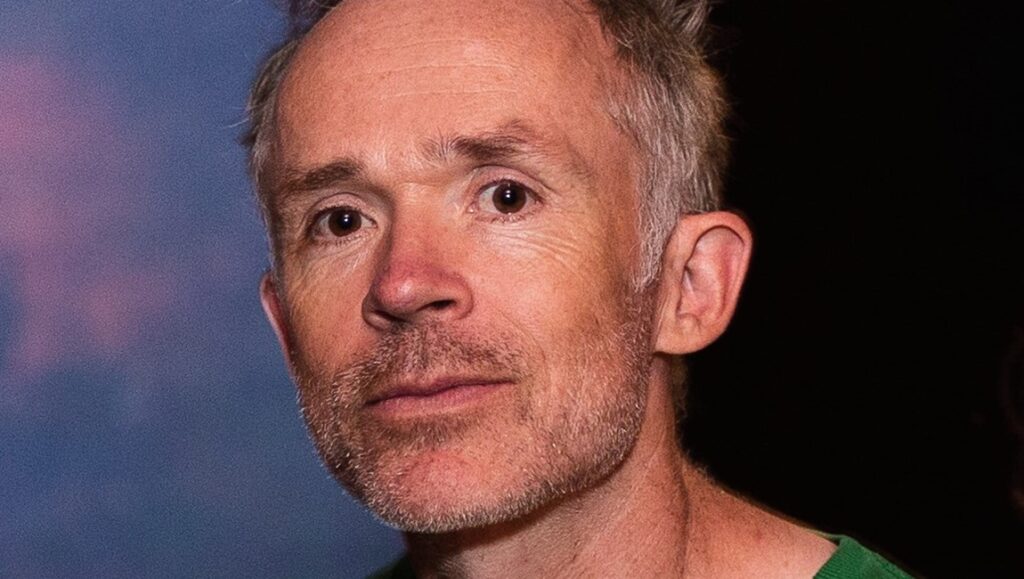 Ben Rivers, director of Bogancloch, portrait. British filmmaker with short grey hair and beard.