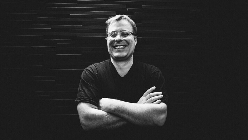 Christoph Hochhäusler at Locarno Film Festival. Black and white portrait with arms crossed.
