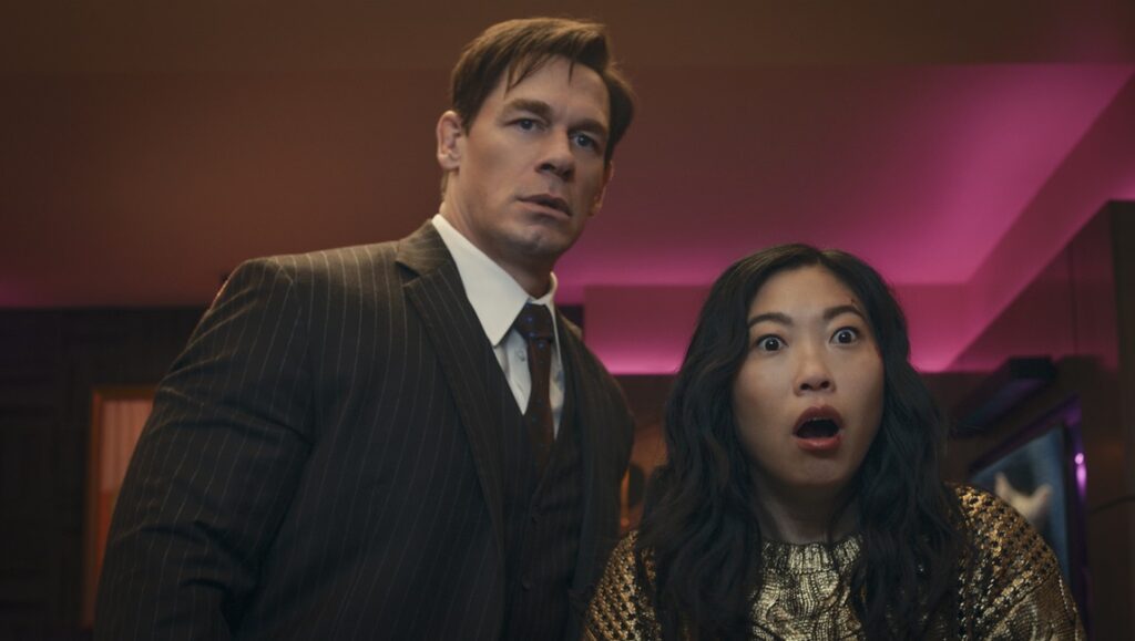 John Cena and Awkwafina in Grand Theft Lotto. Comedy movie still of the two actors looking surprised.