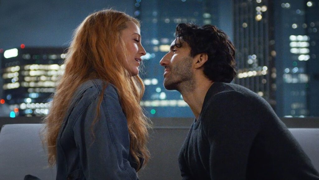 It Ends With Us movie scene: Lily (Blake Lively) and Ryle (Justin Baldoni) face each other against a city skyline.