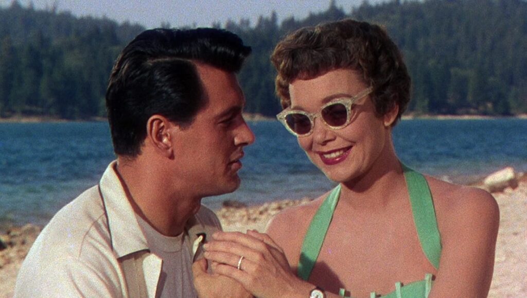 Magnificent Obsession film still. Jane Wyman and Rock Hudson on a beach. Douglas Sirk film.