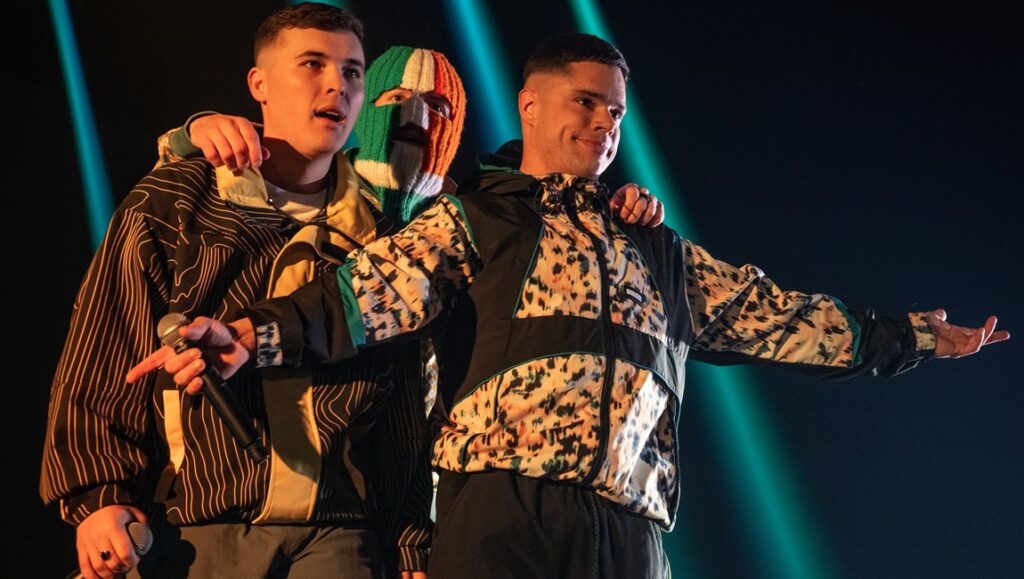 Kneecap band performing live. Irish rappers with balaclava on stage. Rich Peppiatt film review.