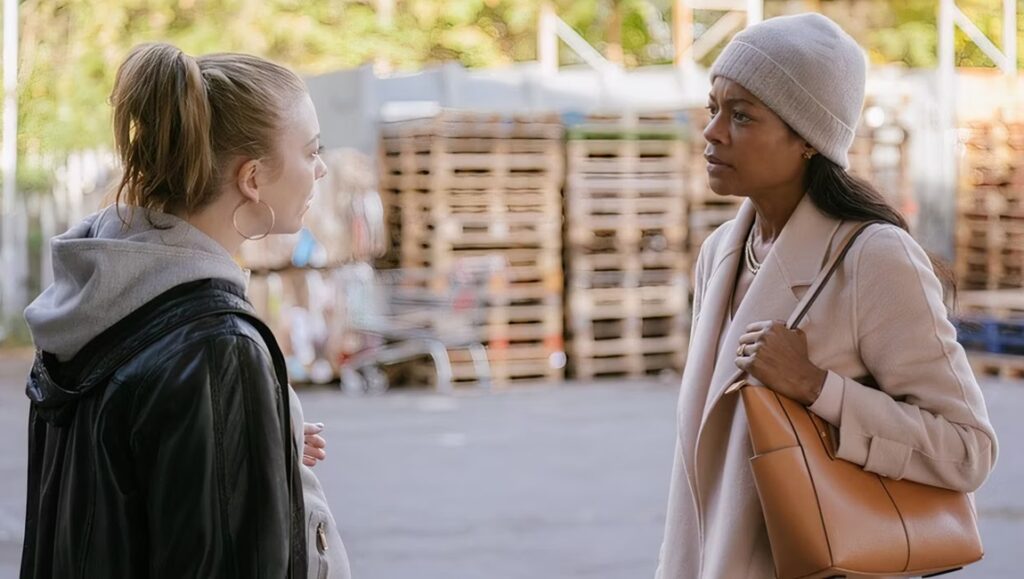 The Wasp movie scene: Two women face each other outdoors. One wears a beanie and coat, the other a hoodie and jacket.