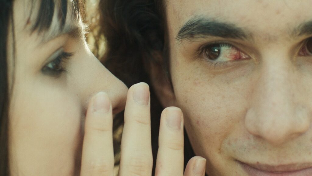 Boomerang film review image: Close-up of Yas Farkondeh whispering to Ali Hanafian. Drama, Venice '24.