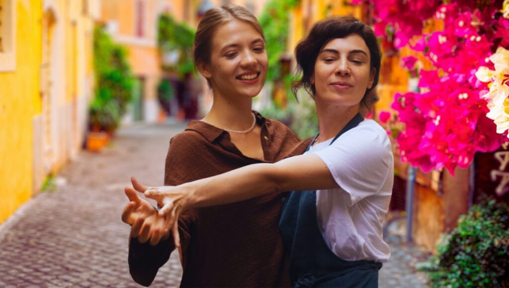 Yeva Sai and Rosa Palasciano in Taxi Monamour. Italian film review, Venice 2024. Movie scene with actresses dancing.