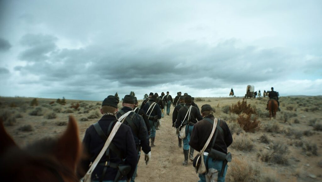 TIFF 2024 — Dispatch 1: Hard Truths, The End, The Substance The Damned at TIFF 2024: Soldiers march across a desolate landscape under a stormy sky. Western film scene.