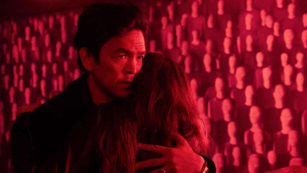 AfrAId film review: John Cho embraces a woman in a red-lit room with mannequin heads on the wall.