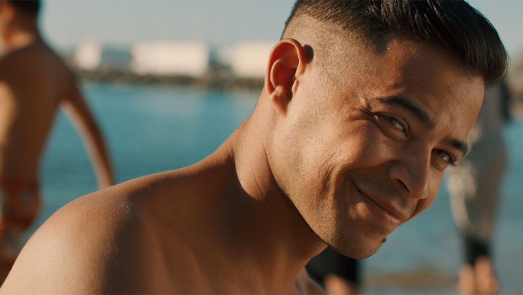 Smiling man on beach. Close-up of happy, tanned skin, short hair. Summer vacation.