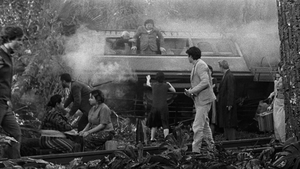 Grand Tour film still. Black and white image of people near a train, some exiting through windows.