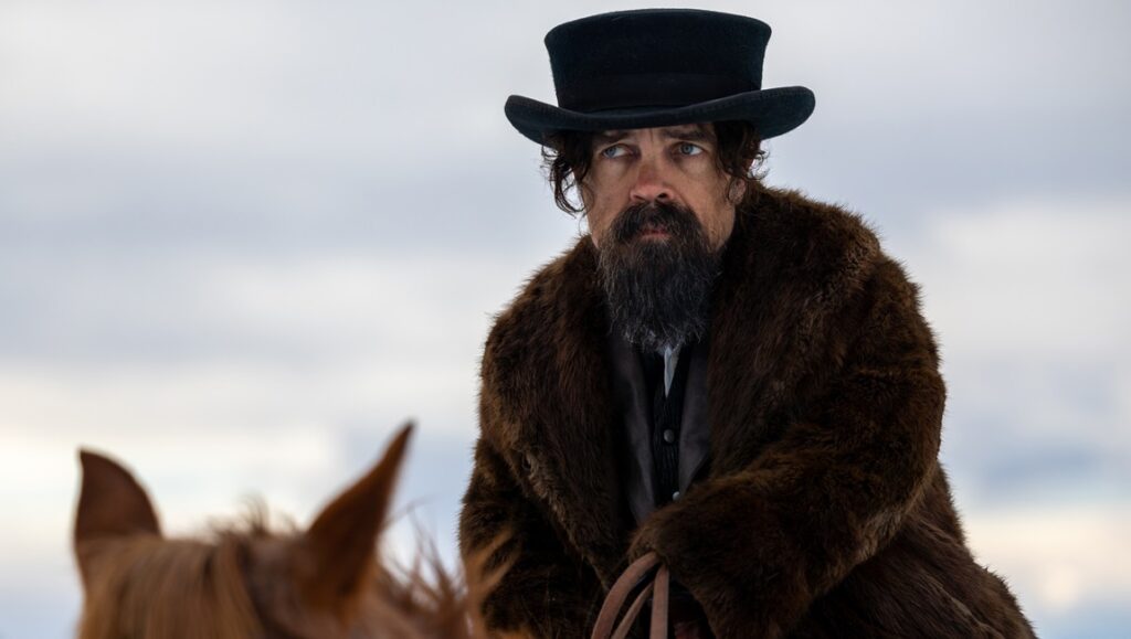 Peter Dinklage in The Thicket movie. Dinklage wears a fur coat and top hat while riding a horse.