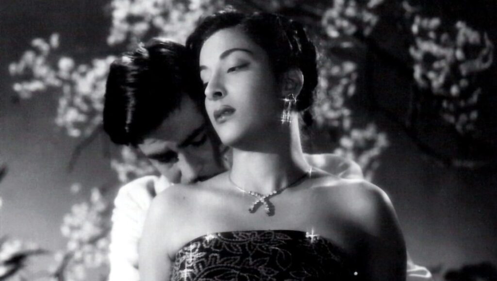 Awaara film still. Raj Kapoor and Nargis Dutt in a romantic embrace, black and white. Classic Bollywood cinema.