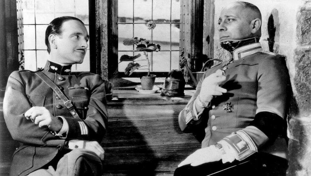 Still from Jean Renoir's Grand Illusion film. Two officers in uniform are talking. Classic cinema.