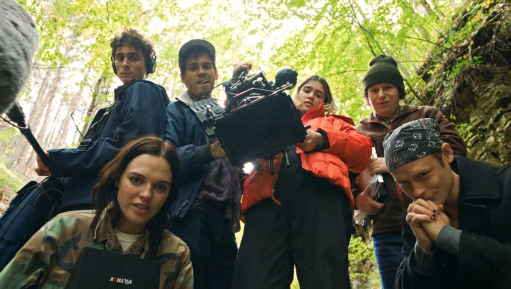 Behind the scenes of My First Film. Zia Anger's film crew in the woods, filming with camera, boom mic, and monitor.