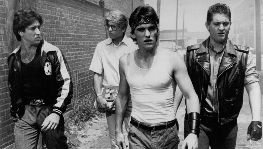 Black and white still from Rumble Fish, directed by Francis Ford Coppola. Matt Dillon leads a pack of greasers.