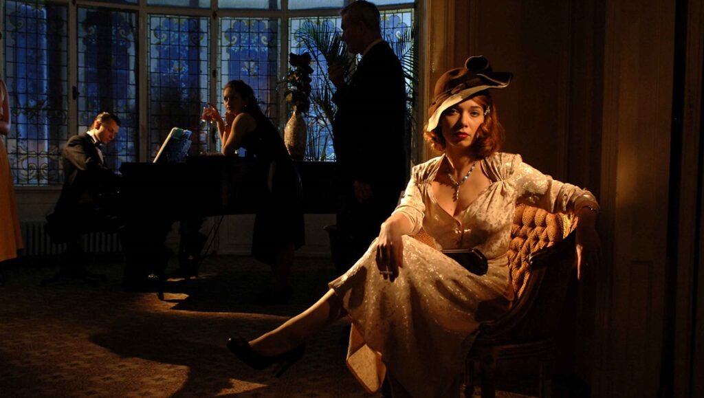 Francis Ford Coppola's Twixt: Woman in vintage dress, man at piano. Period drama scene.