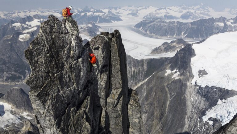 Rock climbers scaling The Devil's Climb mountain peak. Outdoor adventure in a rugged, snowy mountain landscape.