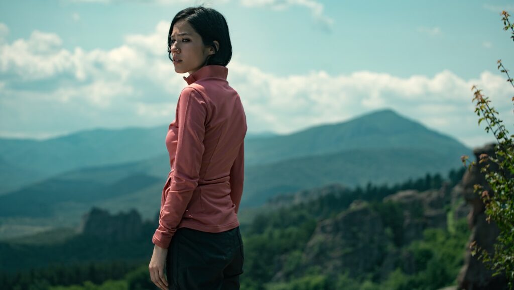 Don't Move movie still: Woman looks back, mountains in background. Adam Schindler and Brian Netto film review.