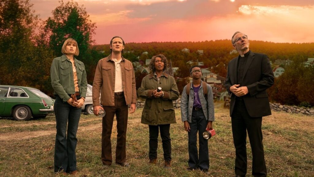 Salem's Lot cast: Alfre Woodard, John Benjamin Hickey, and Lewis Pullman. Group looks up at the sky, flashlights in hand.