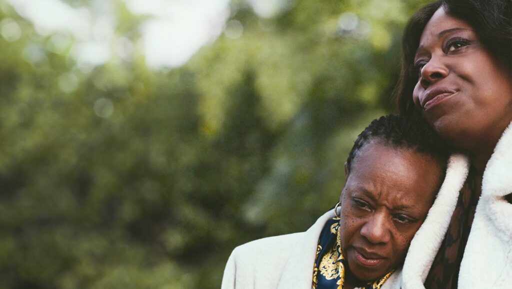 Film still from Mike Leigh's Hard Truths featuring two women in an embrace, one looking comforted.