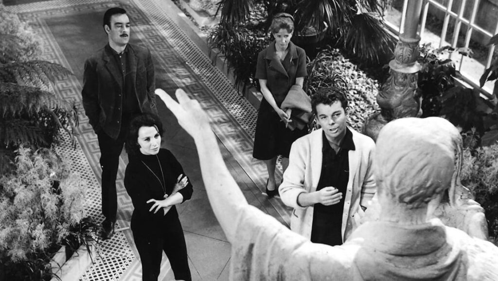 The Haunting — Robert Wise The Haunting movie still. Cast members in black and white film, statue in foreground.