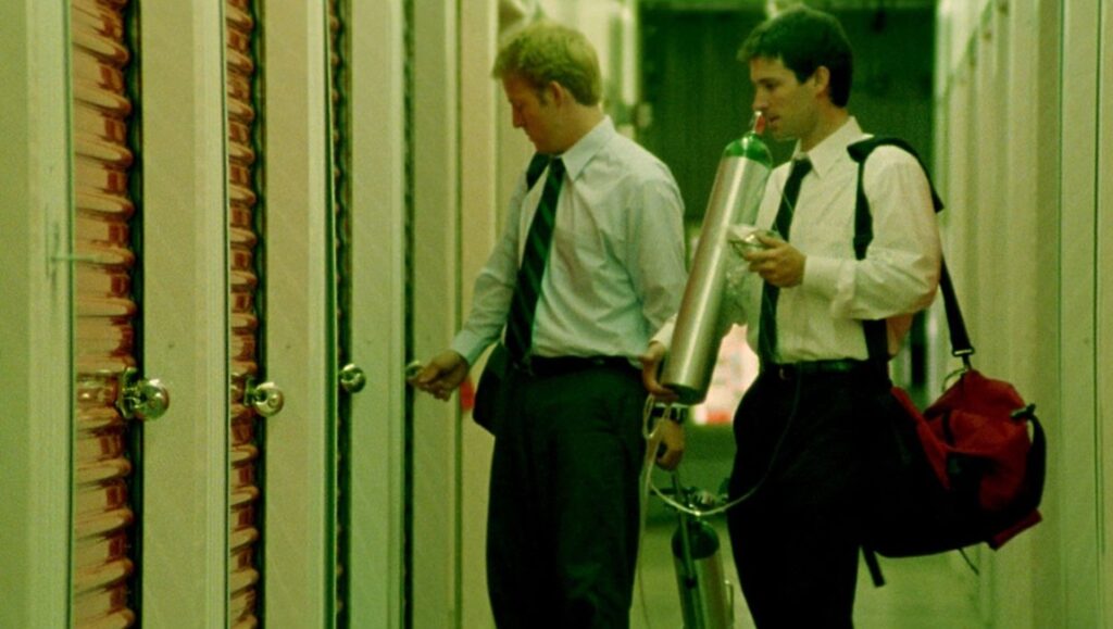 Primer — Shane Carruth Primer film still. Aaron and Abe with oxygen tank, opening time machine device. Shane Carruth movie.