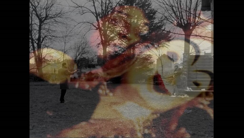 Film still from Scénarios at NYFF 2024. Abstract outdoor scene with figures and trees.