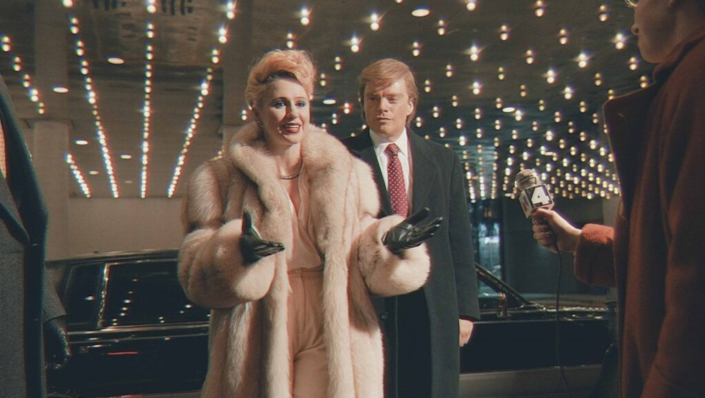 The Apprentice movie scene: Woman in fur coat with Donald Trump, being interviewed.