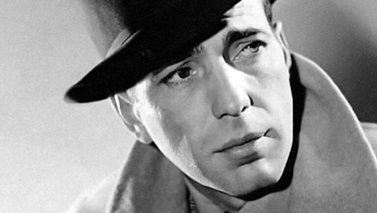 Humphrey Bogart in Bogart: Life Comes in Flashes review. Black and white portrait of the iconic actor wearing a hat.
