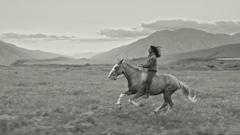 Black and white still from Gaucho Gaucho movie review: woman riding horse in field.