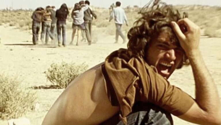 Punishment Park film still. Man screams in desert, group flees in background. Jennifer Reeves, Light Matter '24 review.