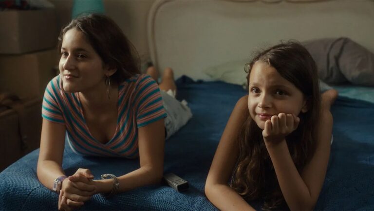 Reinas movie scene: Two girls lie on a bed. Nutcrackers film review.