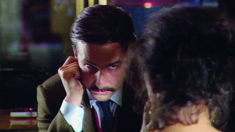 Jean-Luc Godard's Rise and Fall of a Small Film Company film still. Man with mustache looking intensely.