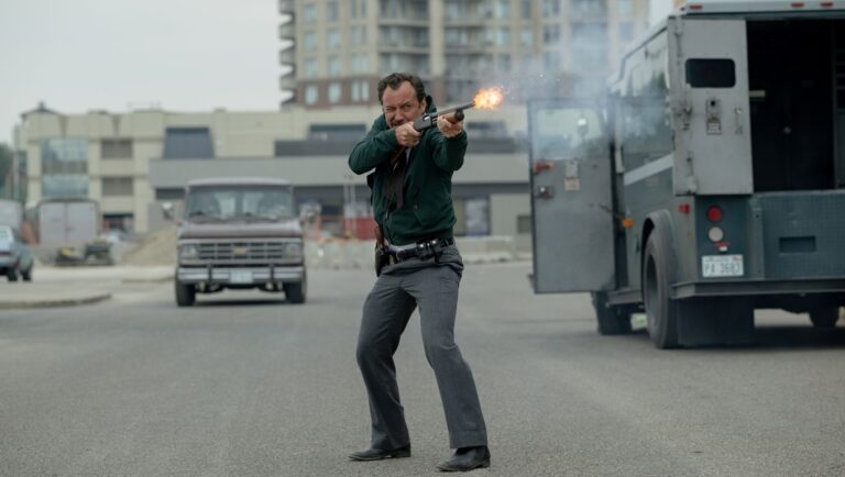 The Order movie scene: Man firing a shotgun near an armored truck. Justin Kurzel film review.