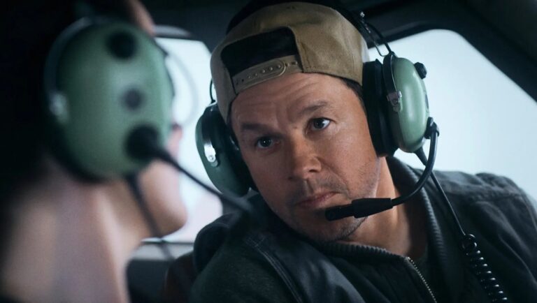 Mark Wahlberg in Flight Risk movie. Actor wearing headset and baseball cap.