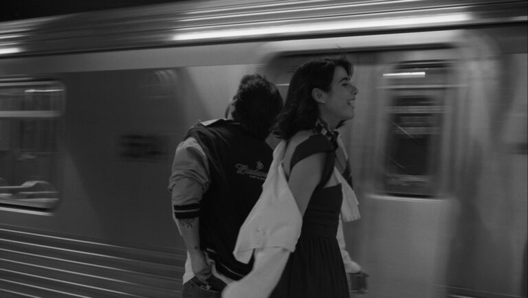 Black and white still from Alice Heart at Slamdance Film Festival 2025. Woman and man standing near a moving train.