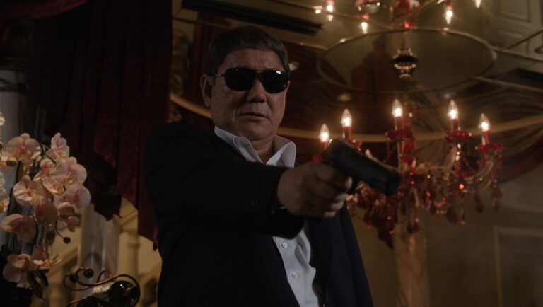 Takeshi Kitano in Broken Rage movie review. Yakuza member aiming a gun.