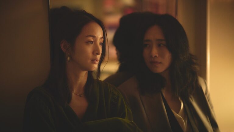 Film still from Blind Love movie. Two Asian women, one in green, the other in a blazer, look concerned.